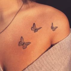 three butterflies on the back of a woman's shoulder