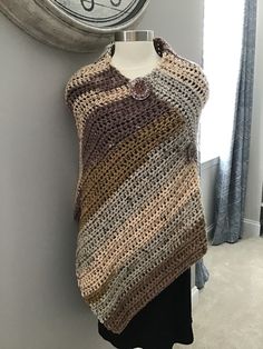 This hand crocheted poncho features rustic colors of brown, gold, tan, peach. It's made with a chunky ever so soft high quality chunky yarn. One size fits most. Machine wash cold water, gentle cycle, dry flat. The front has large wooden buttons in a pumpkin color going down it diagonally as embellishmentonly, not functional buttons. Beige Crochet Poncho For Fall, Handmade Brown Bohemian Poncho, Fall Crochet Beige Poncho, Handmade Beige Poncho One Size, Hand Knitted Brown Poncho For Fall, Handmade Brown Shawl Poncho, Hand-knitted Brown Poncho For Fall, Hand Knitted Beige Poncho For Fall, Ladies Poncho