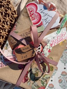 an open gift wrapped in brown paper and tied with a pink ribbon on top of it