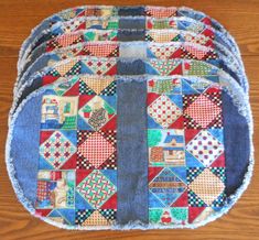 three pieces of blue and red quilted material sitting on top of a wooden floor