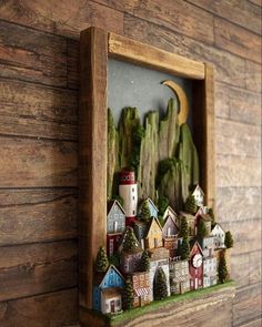 a wooden frame with a small village in it