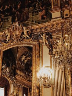 an ornately decorated room with chandeliers and paintings on the wall above it