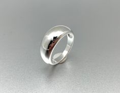 a silver ring with a black arrow on it's side, sitting on a gray surface