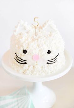 a cake with white frosting and a cat's face is on a plate