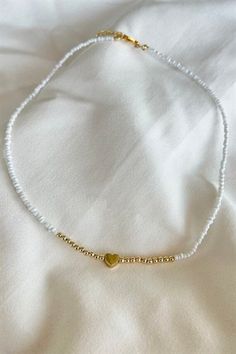 Basic Description: Great simple piece for every occasion. Handmade assorted white seed beaded necklace. With gold color heart figure detail. Very lightweight and dainty. Necklaces are joined with a lobster-style clasp and two inch extended chain.  Sizing:  Each necklace is made with a two inch extender chain so the size can be adjusted to your liking. For example, the 16 inch necklace can be extended up to 18 inches. Care: While necklaces will not be damaged by moisture, avoid getting your necklace wet to prevent potential fading or tarnishing. Seed Beaded Necklace, White Beaded Necklace, White Beaded Necklaces, Dainty Necklaces, 16 Inch Necklace, Color Heart, Seed Bead Necklace, Simple White, Colorful Heart