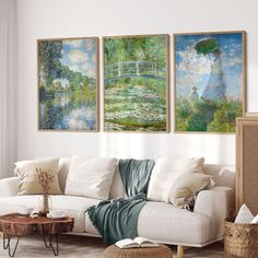 three paintings hang on the wall above a white couch and coffee table in a living room