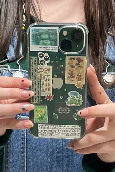 a woman holding up an iphone case with stickers on it's back and hands