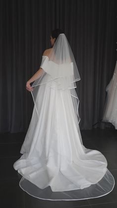 the back of a bride's wedding dress, with her veil draped over it