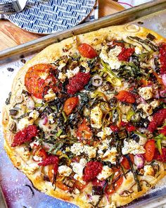 a pizza sitting on top of a pan covered in toppings