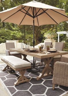 an outdoor dining table with chairs and umbrella