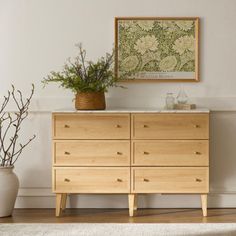 a wooden dresser sitting on top of a hard wood floor next to a white rug