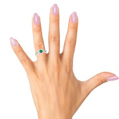 a woman's hand with pink manicured nails and a diamond ring