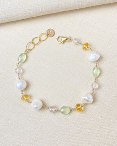 White baroque pearls and faceted pastel gems make a feminine combination in this handcrafted bracelet. The sunny yellow citrine, spring green prehnite, and pale pink rose quartz beads have exquisite micro-faceting, making them shine and shimmer with every movement. I especially love the organic shape of the pearls, which adds a touch of nature to this refined design. I have wire-wrapped every gem and pearlby hand in 14k gold fill, making this bracelet a unique piece that will never go out of style. It's not just a piece of jewelry, it's a symbol of the care and attention that went into creating it. The extender chain allows for an adjustable fit, so you can wear it comfortably all day long. Wearing this bracelet is more than just accessorizing - it's a statement. A statement that says you Elegant Yellow Beaded Bracelets With Gemstone Beads, Elegant Yellow Bracelets With Faceted Beads, Elegant Yellow Bracelets With Gemstone Beads, Elegant Yellow Bracelet With Faceted Beads, Elegant Yellow Gemstone Beads Bracelets, Elegant Yellow Gemstone Beaded Bracelets, Elegant Handmade Pastel Jewelry, Elegant Citrine Bracelets With Gemstone Beads, Elegant Citrine Gemstone Beads Bracelets