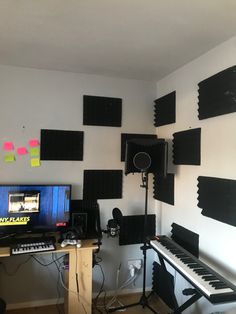 a room that has some musical equipment on the wall and in front of it is a keyboard