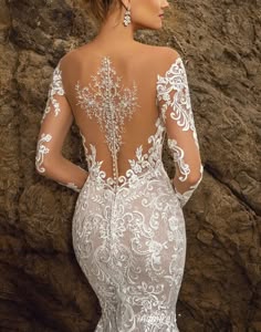 the back of a wedding dress with white lace on it and an open neckline