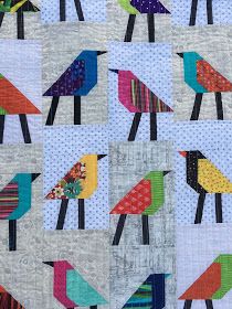 a quilted wall hanging with colorful birds on it