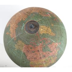 an old globe is sitting on a white surface