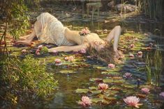 a painting of a woman laying on top of water lillies