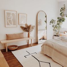 a bed room with a neatly made bed next to a large mirror and wooden furniture