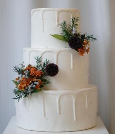 a three tiered white cake with flowers on top