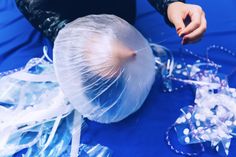 a person is making something out of plastic bags and stringing it on the table