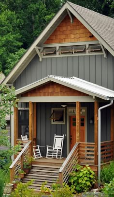 there is a small house with two chairs on the porch and steps leading up to it