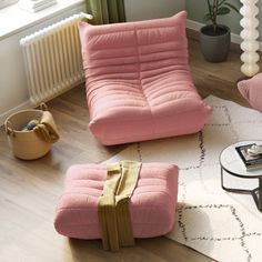 a pink chair and ottoman in a living room