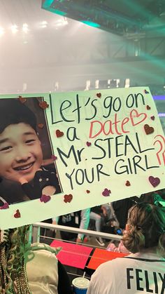 a woman holding a sign that says let's go on a date mr steal your girl