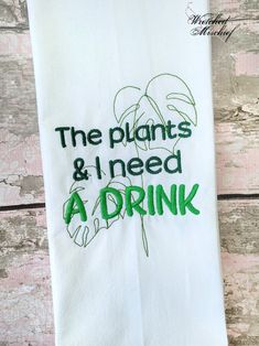 the plants and i need a drink embroidered tea towel in white with green lettering on it