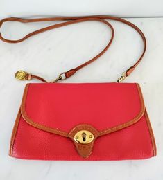 ♥️♥️♥️ Rare, very hard to find bag ! This is the perfect vintage Dooney and Bourke Pebble grain leather crossbody bag in excellent condition  The strap is detable which makes this versatile because it's a clutch as well♥️ Beautiful rich bold red in an all-weather leather that will continue to last a life time due to its amazing quality ! Golden hardware ! Very long Cognac brown leather strap perfect crossbody ! Red and brown leather interior! A true gem for a FB lover and collector !♥️ Reasonable offers are always welcome ♥️ ✨MEASURES: 10 INCHES WIDE AND 6 INCHES TALL ✨✨ I HAVE A TON OF LUXURY, DESIGNER PIECES LISTED IN MY STORE. TAKE A PEEK✨❣️ ✨AS ALWAYS, I OFFER DISCOUNTED/COMBINED SHIPPING ON ALL BUNDLES  MESSAGE ME ANYTIME IF YOU WANT TO PURCHASE MORE THAN ONE ITEM FROM MY SHOP ! ✨ ✨ I Vintage Red Shoulder Bag For Travel, Red Travel Bag With Brass Hardware, Vintage Red Shoulder Bag With Removable Pouch, Vintage Red Crossbody Shoulder Bag, Vintage Red Shoulder Bag With Leather Lining, Red Vintage Shoulder Bag With Gold-tone Hardware, Red Vintage Shoulder Bag With Leather Lining, Vintage Red Shoulder Bag With Detachable Strap, Vintage Dooney And Bourke