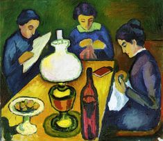 three women are sitting at a table with wine and food on it, while one woman is reading