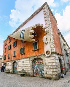 an unusual building with graffiti on it's side