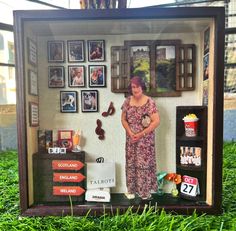 a woman standing in front of a display case with pictures on the wall and floor