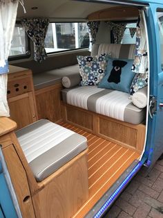 the interior of an rv with couches and pillows on it's side door