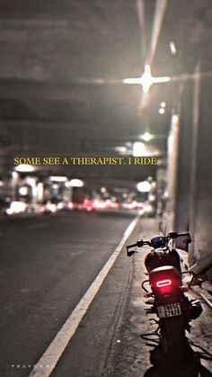 a red motorcycle parked on the side of a road next to a street sign that says, some see a therapist i ride