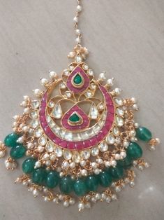 *It's Handmade Kundan Mangtikka for Indian Brides. *It's made from Silver n Copper with White and Pink Kundan Stones Settings with 22k gold Plating as shown in picture. *It's 2.3 Inch size and beaded with emerald green beads and pearls like shown in picture. *Our all jewelry is made from semiprecious stones and beads. *WARRANTY: ITS GENUINE HANDMADE JEWELRY AND WE ARE GIVING LONG LIFE WARRANTY FOR OUR ALL ITEMS. All of our Kundan Jewelry is 100% handmade with ancient Kundan stone setting method Bridal Tikka, Wedding Choker Necklace, Pakistani Brides, Tikka Jewelry, Unique Wedding Jewelry, Kundan Jewelry, Gold Necklace Indian Bridal Jewelry, Bridal Diamond Jewellery, Indian Jewellery Design Earrings