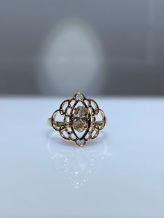 10K yellow gold filigree ring with 0.25 genuine oval shaped diamond. The elongated oval shaped diamond is graded as an SI1 and it has a lovely champagne color that pairs so nicely with the yellow gold. It's 15mm at its widest point and tapers down to 2.5 mm at the base of the shank. The scroll/filigree work of the mounting is simply gorgeous. This would make a very unique engagement ring. It also looks great as a right hand ring. Very rich looking! Finger size is 6. Resizing, if needed, comes co Antique Oval Diamond Ring With Single Diamond, Antique Oval Single Diamond Ring, Oval Diamond Filigree Jewelry, Vintage Oval Diamond Ring With Single Diamond, Vintage Oval Diamond Ring With Single Stone, Antique Oval Diamond Ring With Center Stone, Oval Rose Cut Diamond Heirloom Ring, Elegant Oval 14k Gold Diamond Ring, Oval Heirloom Ring With Rose Cut Diamonds