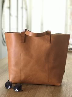 "Oversized camel leather bag, made with the highest quality veg tanned leather. Its clean design and its 7 inches depth makes this beautiful bag a versatile bag to carry many things. Features: - Highest quality Full Grain Veg Tanned leather - Aprox Size: 14 in wide at the bottom, at the top, the width depends on how full is the bag, but it should be around 15-17 inches (36 cm at bottom - wider at the top - maybe 40-42 cm) - easily fits a 15\" laptop 13 in high (33 cm) 7 inches deep (18 cm) - 3 b Large Capacity Camel Tote Satchel, Camel Tote Bag With Leather Handles, Dark Tan Bags With Leather Lining For Everyday Use, Dark Tan Bag With Leather Lining For Everyday Use, Rectangular Caramel Shoulder Bag For Daily Use, Camel Tote Shoulder Bag For On-the-go, Camel Tote Satchel For On-the-go, Camel Satchel Tote For On-the-go, Camel Shoulder Bag Tote For On-the-go