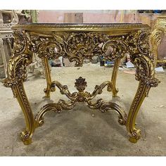 an ornate gold console table in the process of being polished and painted with acrylic paint