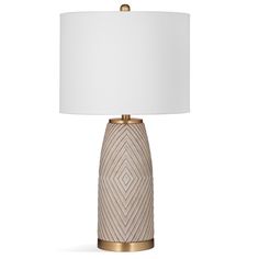 a table lamp with a white shade on the top and gold trimming around it