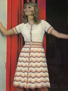 a woman standing in front of a red door with her hands out to the side