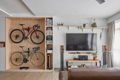 a living room filled with furniture and a flat screen tv next to a bike mounted on the wall