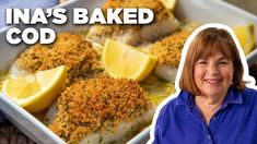 a woman standing in front of a baking dish with lemons and breaded chicken