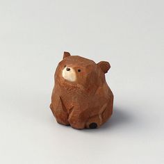 a brown bear figurine sitting on top of a white surface