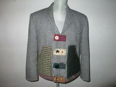 a gray jacket with patches and buttons on it