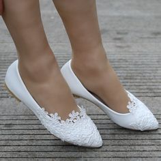 a woman's white shoes with lace detailing on the toes and heels are shown