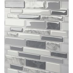 a white and grey tile wall with some black and white tiles on it's side