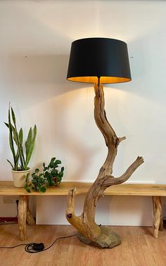 a wooden table with a lamp on it and a potted plant next to it