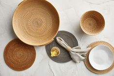 woven placemats, plates and napkins are laid out on a white surface