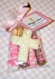 a pink and white candy bar wrapped in cellophane with a cross on it